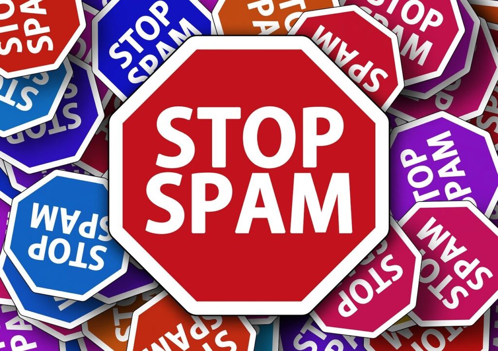 Señales de advertencia con la palabra spam, representando correos no deseados.
